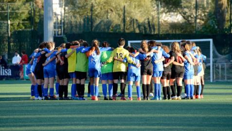 Las jugadoras de los dos equipos, abrazadas en el centro del terreno de juego