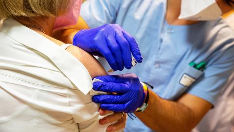 Una sanitaria suministra una vacuna a una mujer