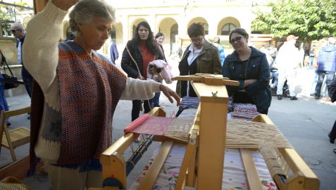 Varias personas observan trabajos con lana en unas ferias