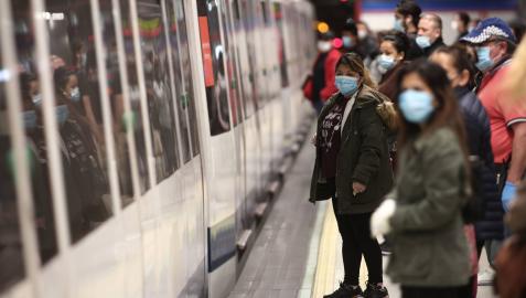 Viajeros con mascarillas en un andén de la estación de metro de Nuevos Ministerios en Madrid