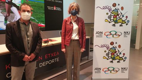 Primitivo Sánchez, subdirector del Instituto Navarro del Deporte y la consejera de Cultura y Deporte, Rebeca Esnaola, junto a un cartel con el logotipo y la mascota de los juegos. Primitivo Sánchez, subdirector del Instituto Navarro del Deporte y la consejera de Cultura y Deporte, Rebeca Esnaola, junto a un cartel con el logotipo y la mascota de los juegos