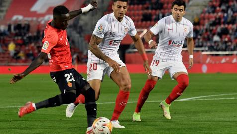 Los sevillistas Diego Carlos y Marcos Acuña disputan un balón a Ndiaye, del Mallorca, en el partido disputado este miércoles en Son Moix