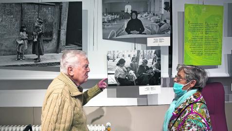 Dos personas comparten recuerdos en la exposición ‘Mujeres y cuidados’ en la Casa de Misericordia