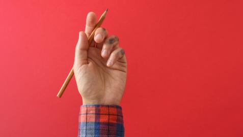 Un niño sujeta un lapicero con la mano izquierda