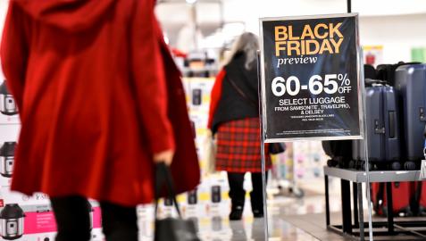 Clientas pasando junto a un cartel del Black Friday Clientas pasando junto a un cartel del Black Friday