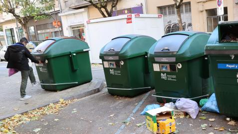 Una persona se dispone a abrir el contenedor con tarjeta para introducir su bolsa, en la calle Sangüesa de Pamplona