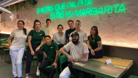 El equipo de Margarita Malapata junto a uno de los neones del restaurante