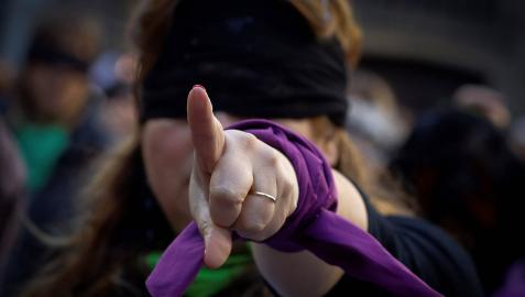 Una mujer con los ojos vendados en un flashmob contra la violencia machistas