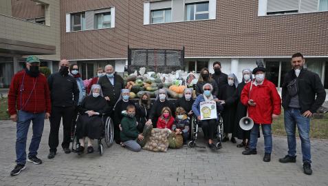 Hermanitas de los Pobres, residentes y los mozos de la peña Alegría posan con los alimentos recién llegados