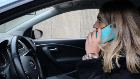 Una mujer habla por teléfono móvil dentro de su coche Una mujer habla por teléfono móvil dentro de su coche