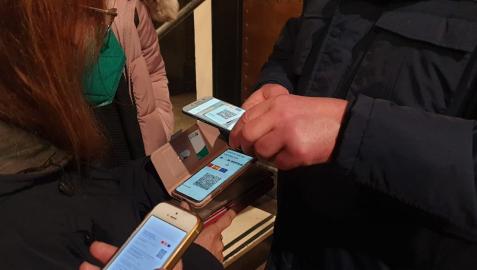 Varias personas muestran su pasaporte covid para entrar a un local Varias personas muestran su pasaporte covid para entrar a un local