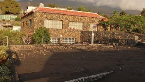 23 DE SEPTIEMBRE La casa, cuando la familia fue a sacar sus enseres, con el volcán (al fondo) en erupción 23 DE SEPTIEMBRE La casa, cuando la familia fue a sacar sus enseres, con el volcán (al fondo) en erupción
