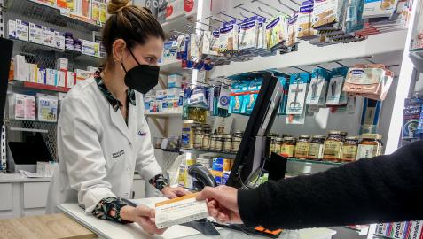 Una farmacéutica dispensa un autotest covid Una farmacéutica dispensa un autotest covid