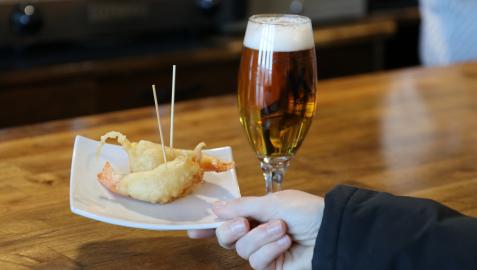 Imagen de un pincho de frito de gamba y una caña en la barra de un bar Imagen de un pincho de frito de gamba y una caña en la barra de un bar