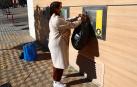 Una mujer se dispone a introducir su bolsa en un buzón