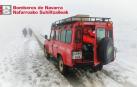 Un camion de bomberos junto a unos peregrinos que caminan entre la nieve