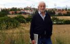El pintor Pedro Salaberri posa en su lugar escogido para la serie junto con un libro que recoge varias de sus obras