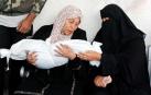 Dos mujeres palestinas, junto al cuerpo sin vida de un niño gazatí