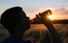Un joven bebe un botellín de cerveza