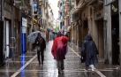 Varias personas caminan bajo la lluvia por la calle San Nicolás de Pamplona, este viernes
