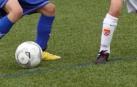Dos niños juegan a fútbol