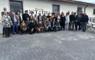 Asistentes al acto posan junto al mercado social inaugurado en el edificio polivalente en que se ha transformado la antigua bodega cooperativa de Arizala,