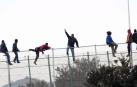 Decenas de inmigrantes se encaraman a la valla de Melilla