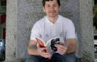 Bill Hilmann, con un ejemplar en inglés de su libro, en la estatuta dedicada a Hemingway en la plaza de toros.