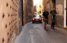 Varias personas pasean por la calle Verjas, con un coche al fondo.