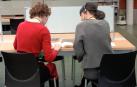 La voz susurrante ha pedido a una de las participantes que guíe con su dedo a la otra en la lectura de uno de los libros.