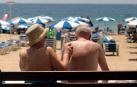 Pareja de turistas aplicándose crema solar en Benidorm.