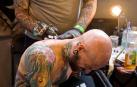 Un tatuador realiza un tatuaje.