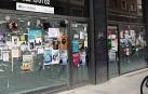 Decenas de carteles publicitarios llenan el escaparate de un local comercial de la calle Bergamín.