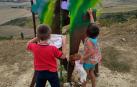 Voluntarios limpian los grafitis del Monumento al Peregrino en El Perdón