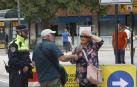 Dos peatones preguntan sobre los cambios de tráfico a un policía municipal a la entrada del paseo Sarasate.