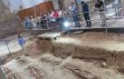 El director de las excavaciones de San Nicolás, Juanjo Bienes -a la izda.-, explica las claves de los trabajos durante una de las visitas.