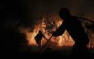 Bomberos y brigadas forestales de la Xunta de Galicia apagan un incendio.