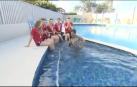 Entrevista a unos nadadores, tropieza y se sumerge en la piscina