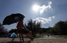 Varias personas se alivian del calor en el pantano de Alloz y en el río Arga a su paso por Irotz.