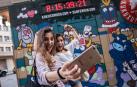 Dos jóvenes se fotografían con el reloj de Kukuxumusu que anunciaba la cuenta atrás para San Fermín.