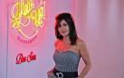 Beatriz Sota junto a las luces de neón que anuncian el nuevo nombre de su peluquería.