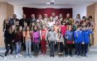 La corporación del Ayuntamiento de Zizur acompañando a los nuevos corporativos infantiles recién elegidos, que portan las varas de mando, junto a los demás niños que les pasan el relevo.