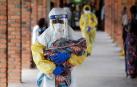 Un sanitario porta a un bebé sospechoso de estar infectado con ébola en el Congo.