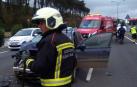 Los bomberos limpian la calzada tras el accidente.