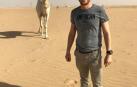 Iñaki Aranguren posa junto a un dromedario sobre la inhóspita inmensidad del desierto saudí.