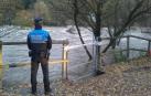 Un agente de la Policía Municipal de Pamplona vigila el cauce del río Arga.
