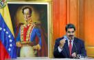 Nicolás Maduro sostiene un miniejemplar de la Constitución venezolana en una conferencia de prensa en el Palacio de Miraflores.