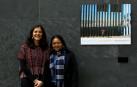 Andrea Villaseñor y Karla Rivas, con una fotografía del periodista Iván Benítez tomada en la valla de Tijuana y que se expone en el Parlamento de Navarra como parte de la muestra 'Stand by: más allá de las fronteras'.