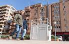 Dos hombres pasan junto a la estación de medición de Tudela.