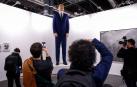 Varias personas observan el "ninot" del rey Felipe VI ,una obra de Santiago Sierra y Enrique Merino, expuesta en ARCO 2019.